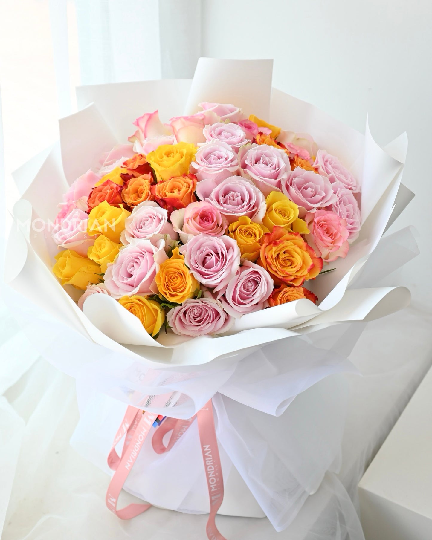 a 50 stalks rose bouquet in brightly mixed colors, with pink, yellow and orange roses