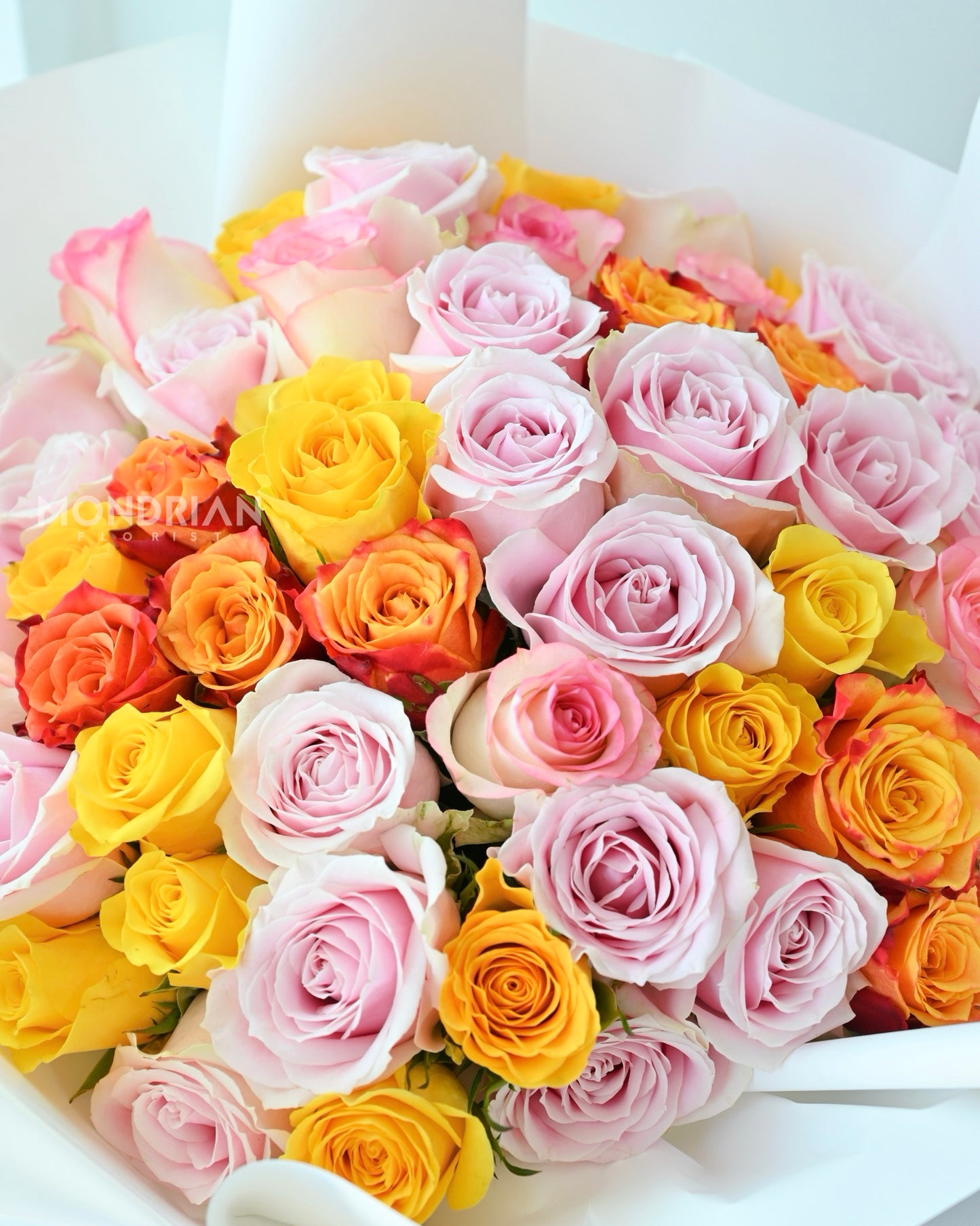 a 50 stalks rose bouquet in brightly mixed colors, with pink, yellow and orange roses