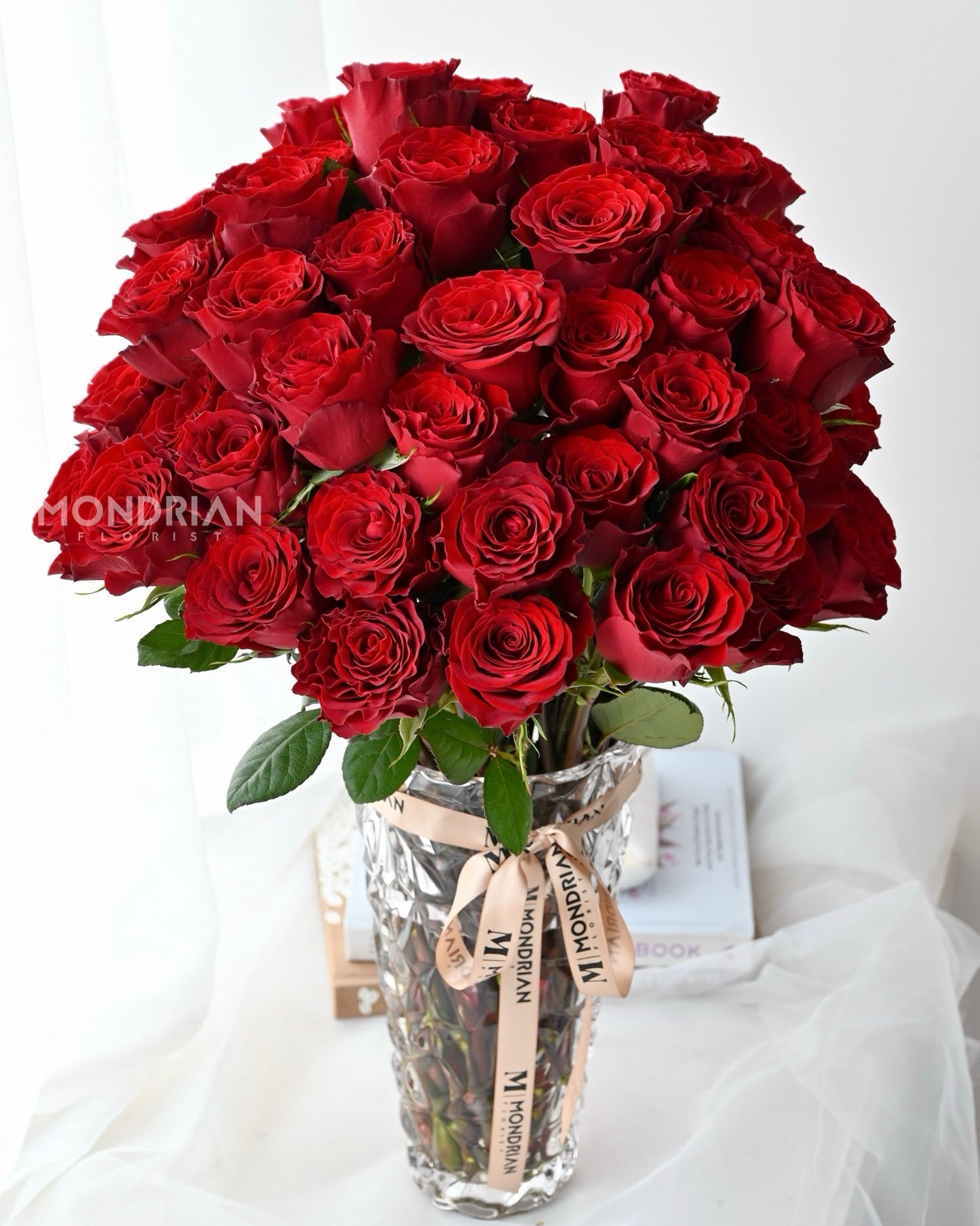 50 stalks red roses in clear glass tall vase