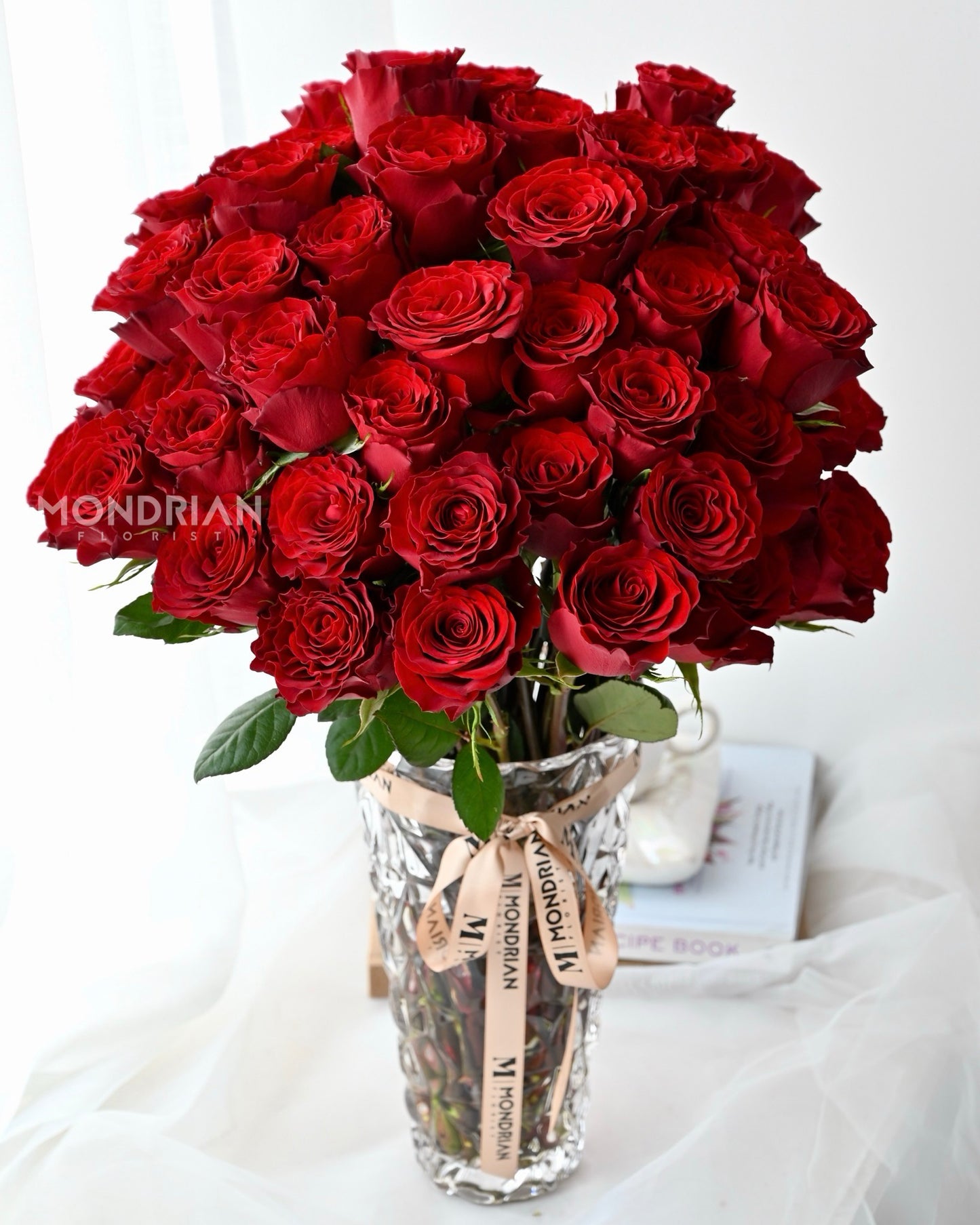 50 stalks red roses in clear glass tall vase