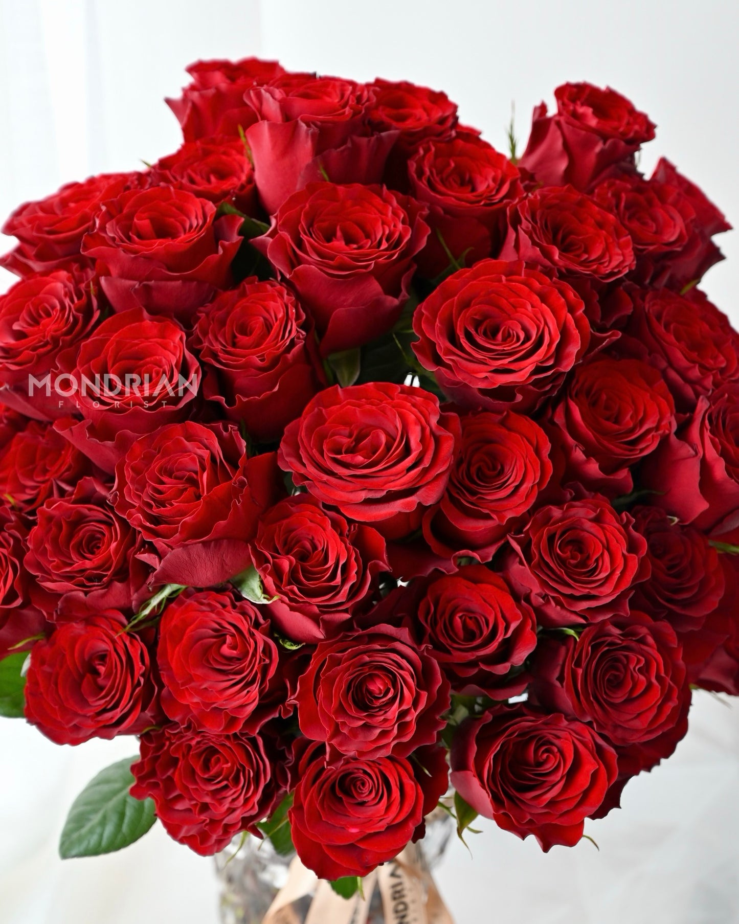 50 stalks red roses in clear glass tall vase