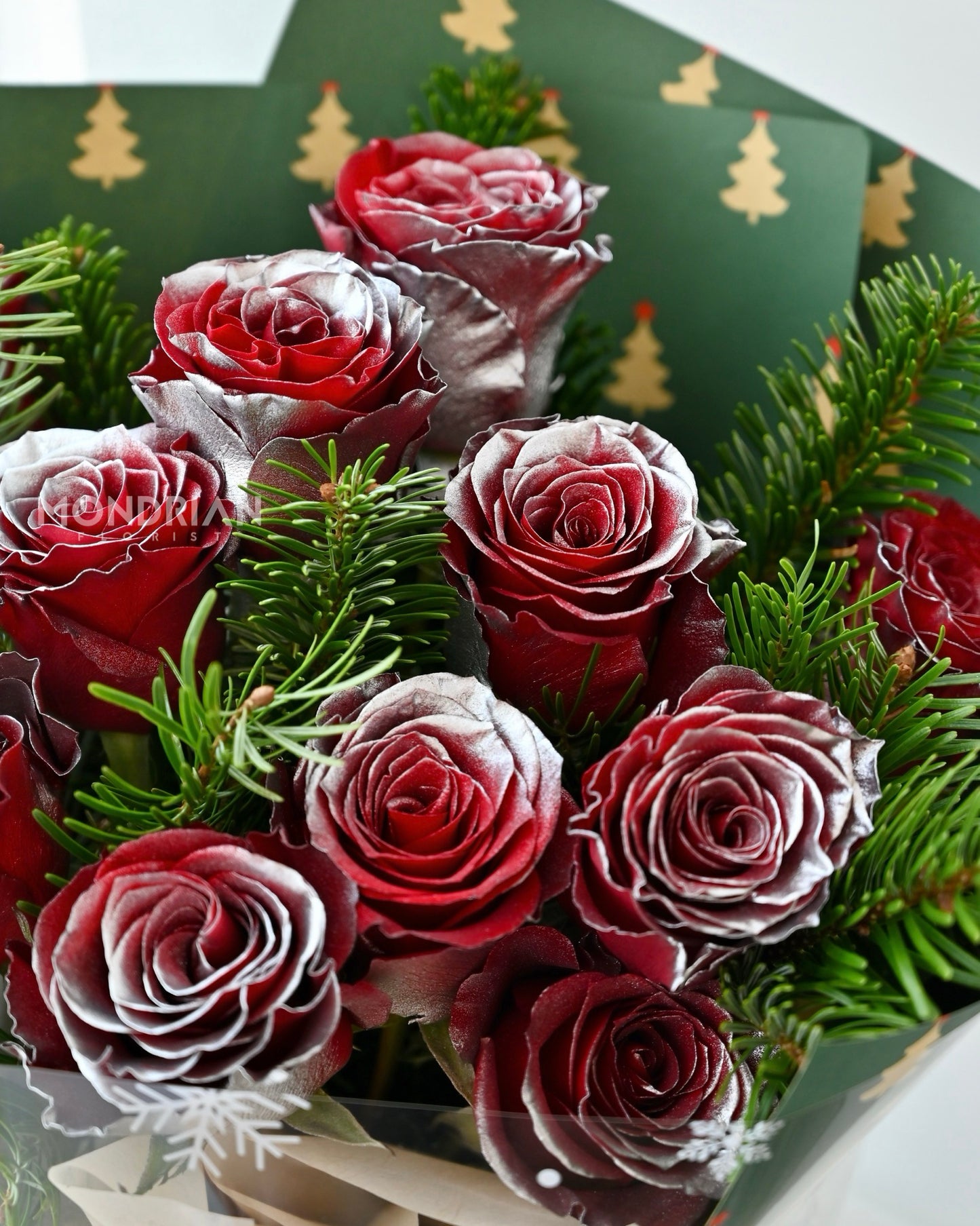close up of a christmas flower bouquet with red roses and nobilis fir