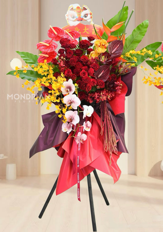 a luxury tripod shop opening flower stand with red and yellow flowers including orchids and roses