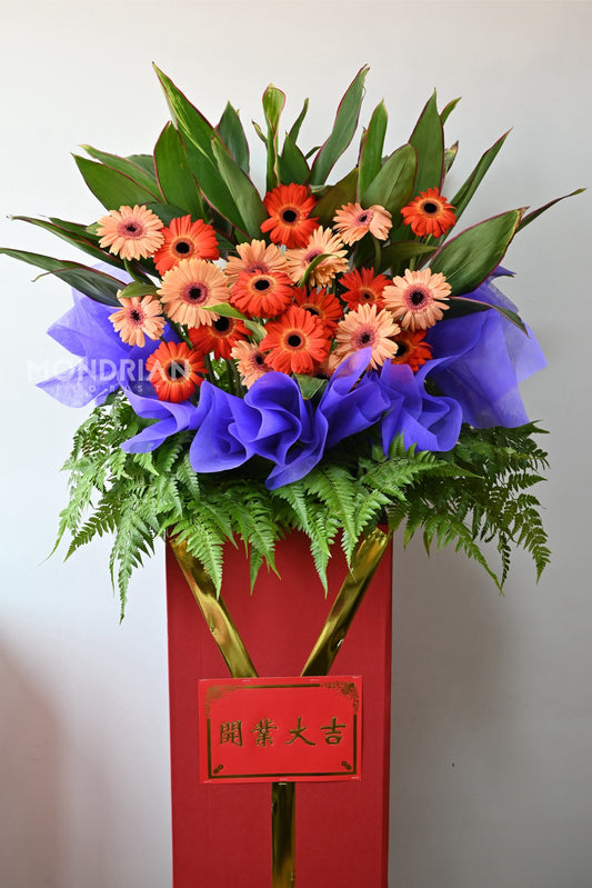 a classic gran opening flower stand with gerbera flowers and green foliages