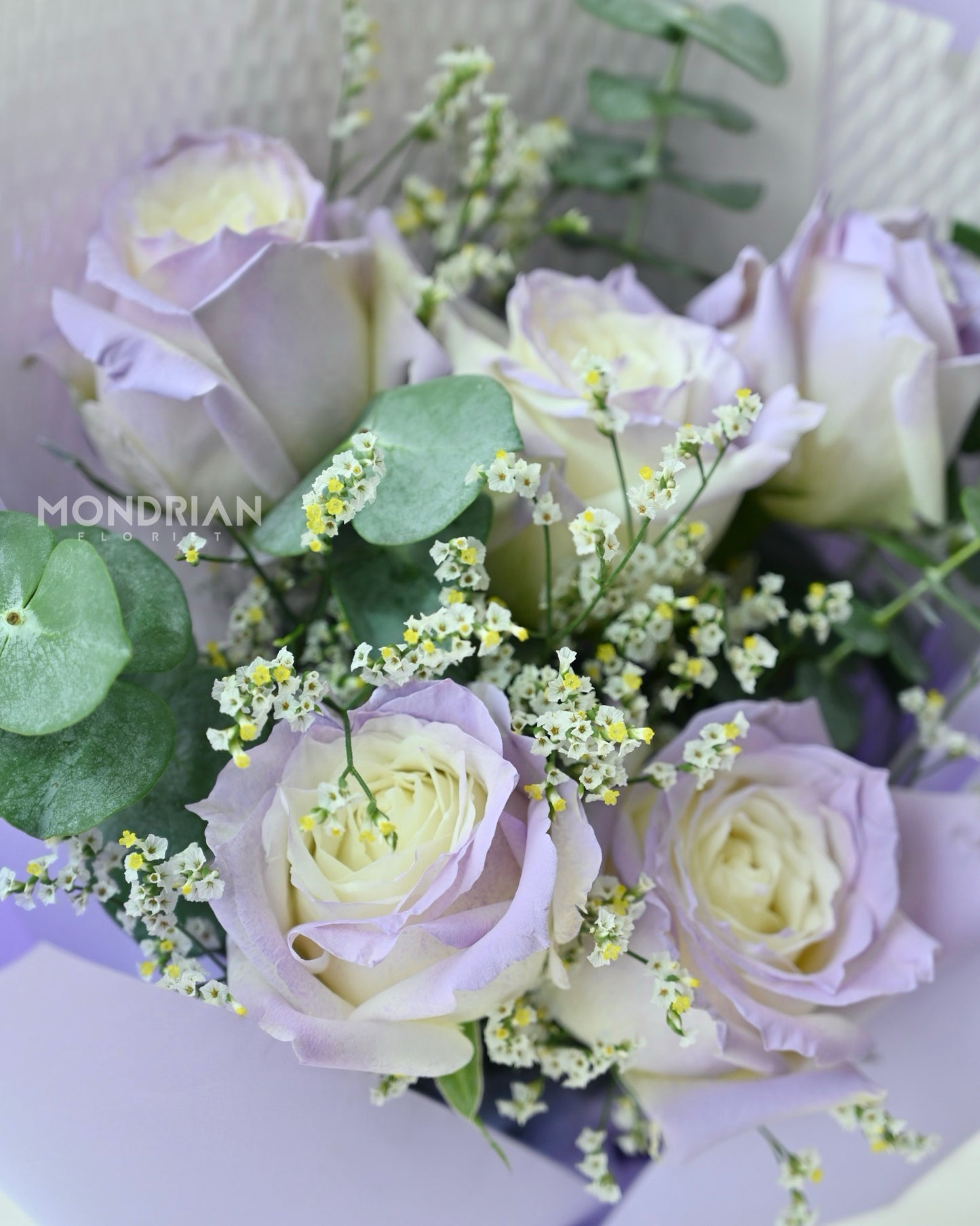 close up a bouquet of lilac rose bouquet with limonium flower bouquet by Mondrian Florist