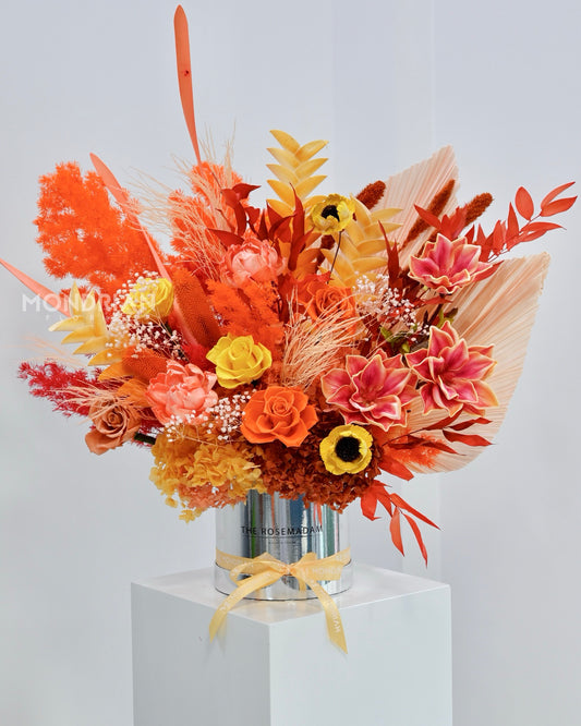 a luxury box of dried flowers and preserved roses, in warm orange and amber color