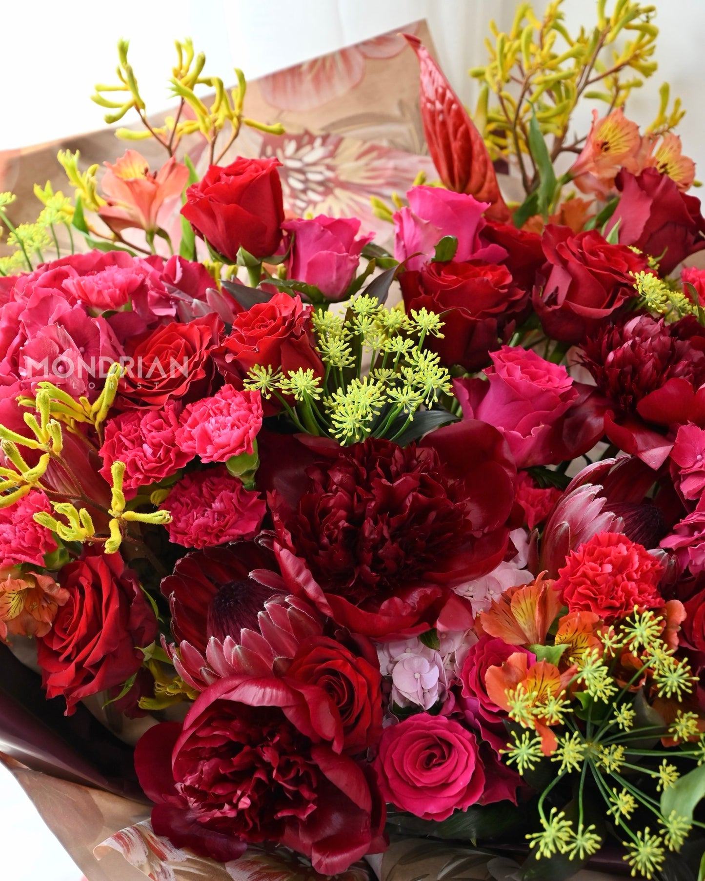 a luxury flower bouquet with red peony, red roses, anthurium and many more flowers by Mondrian Florist