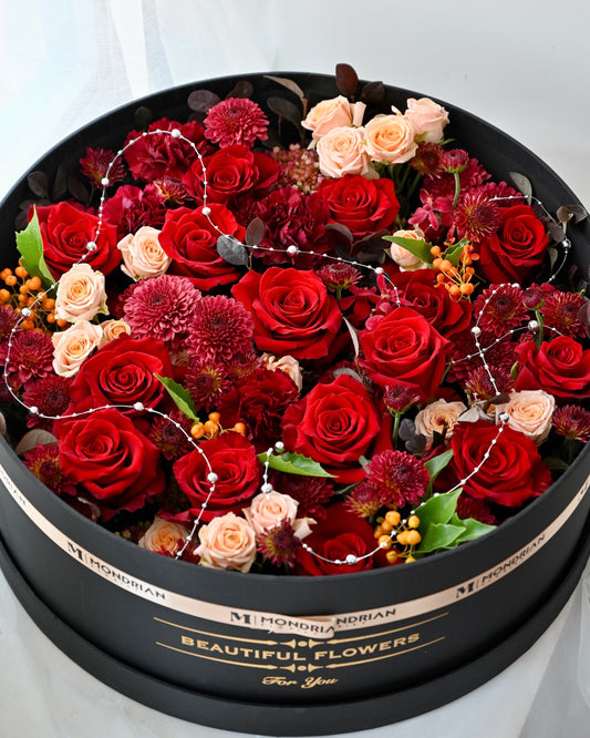 a big flower box with red theme flowers and berries