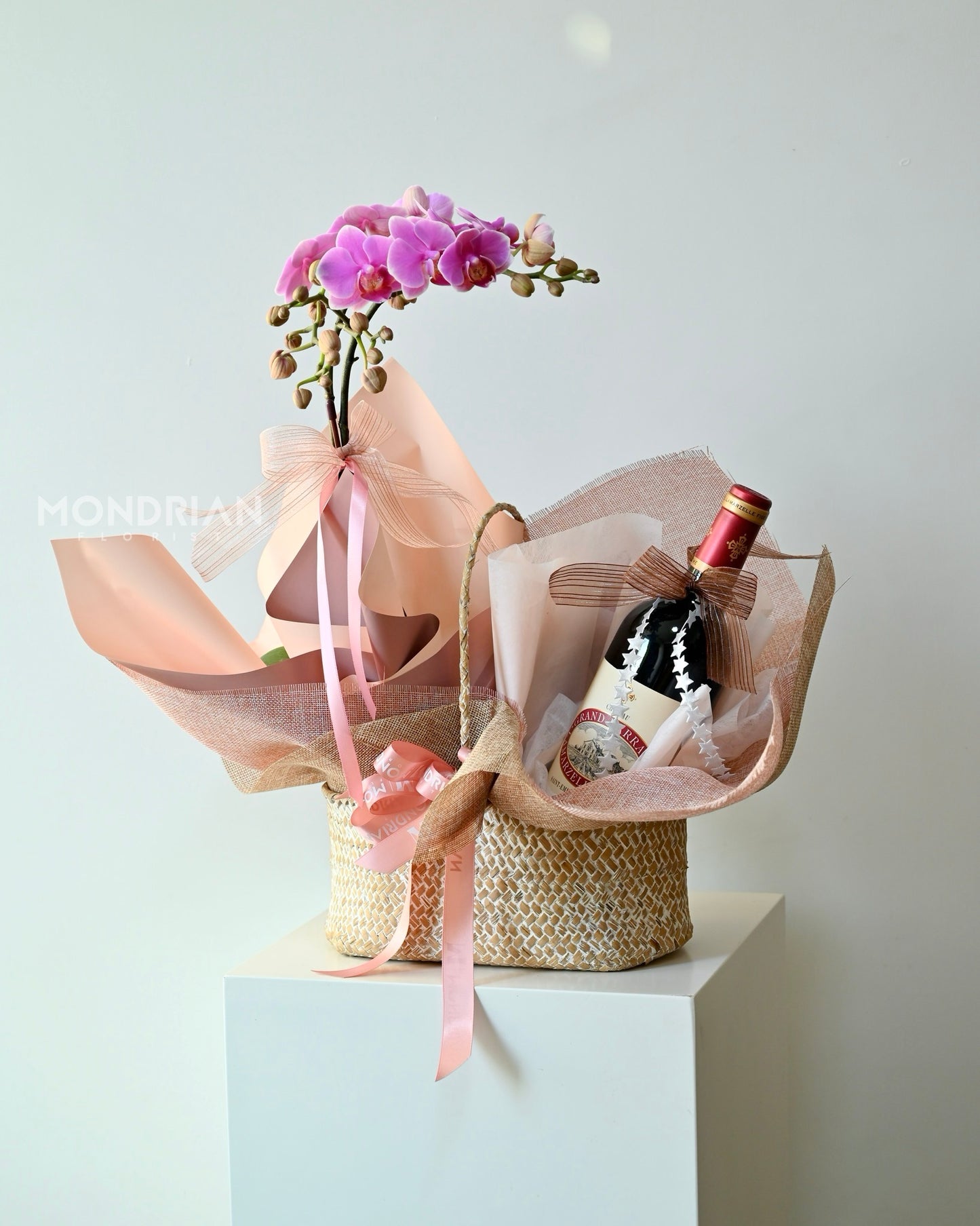 a luxury gift hamper with a orchid pot and a bottle of wine