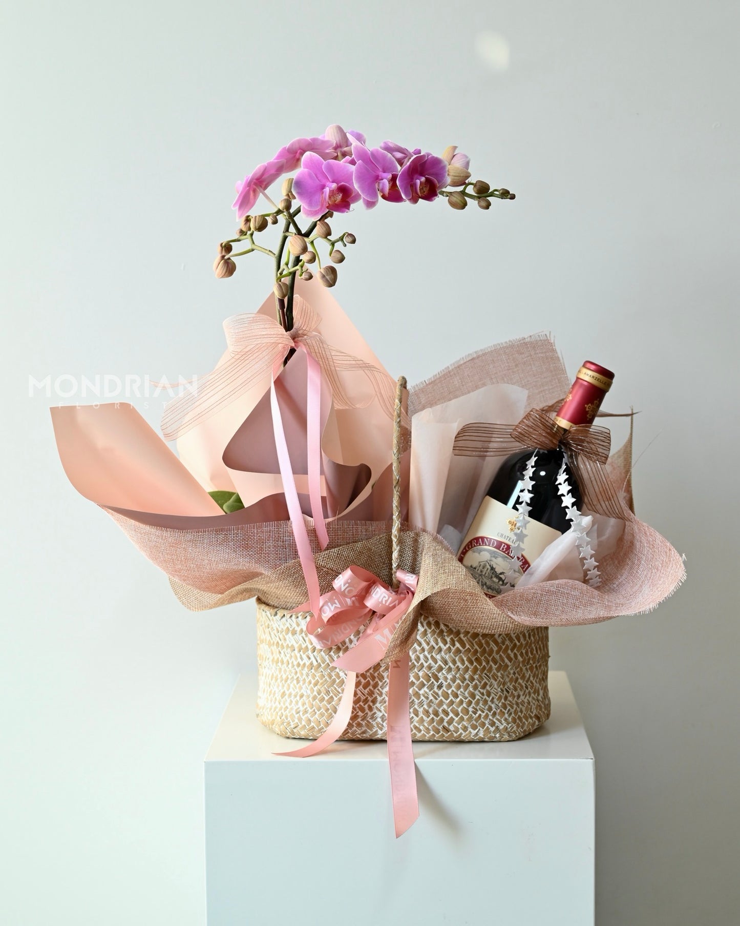 a luxury gift hamper with a orchid pot and a bottle of wine