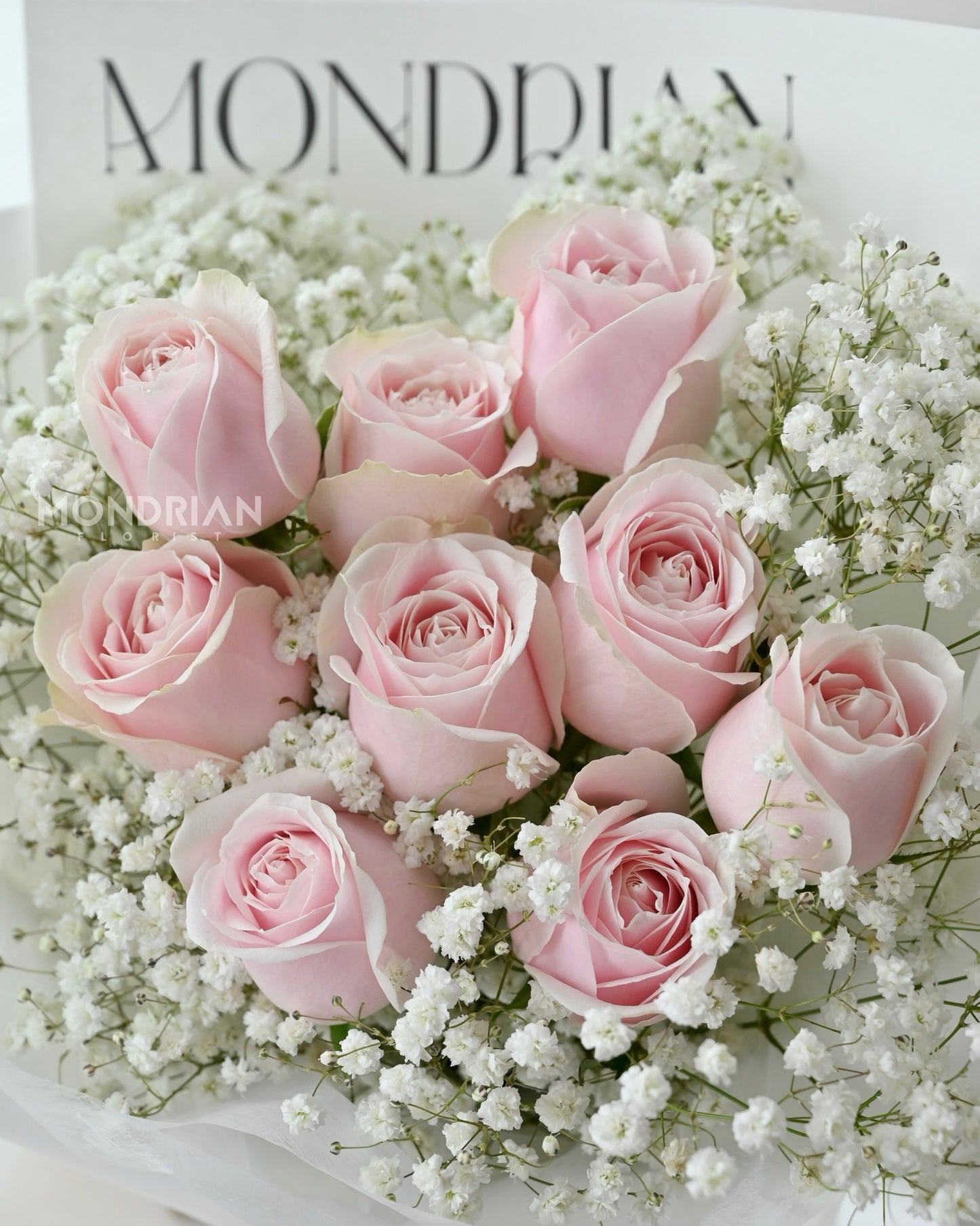 a bouquet of 9 stalks of pink roses and baby's breath by Mondrian Florist