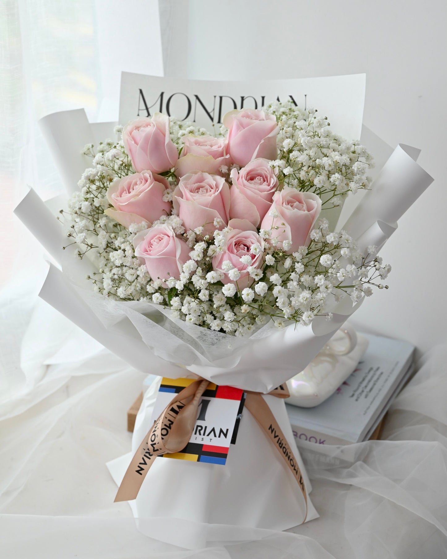 a bouquet of 9 stalks of pink roses and baby's breath by Mondrian Florist