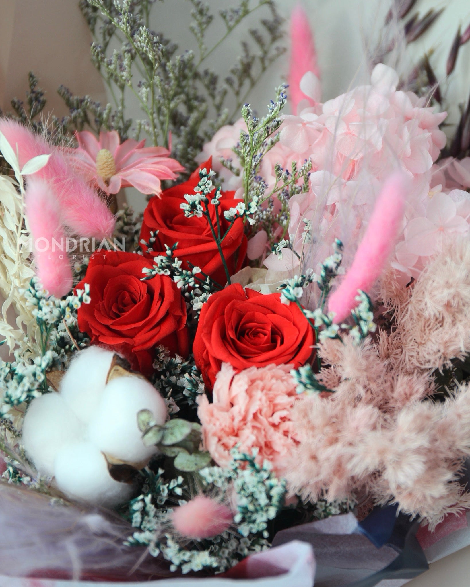 close up of a flower bouquet with preserved roses and assorted filler flowers including preserved hydrangea