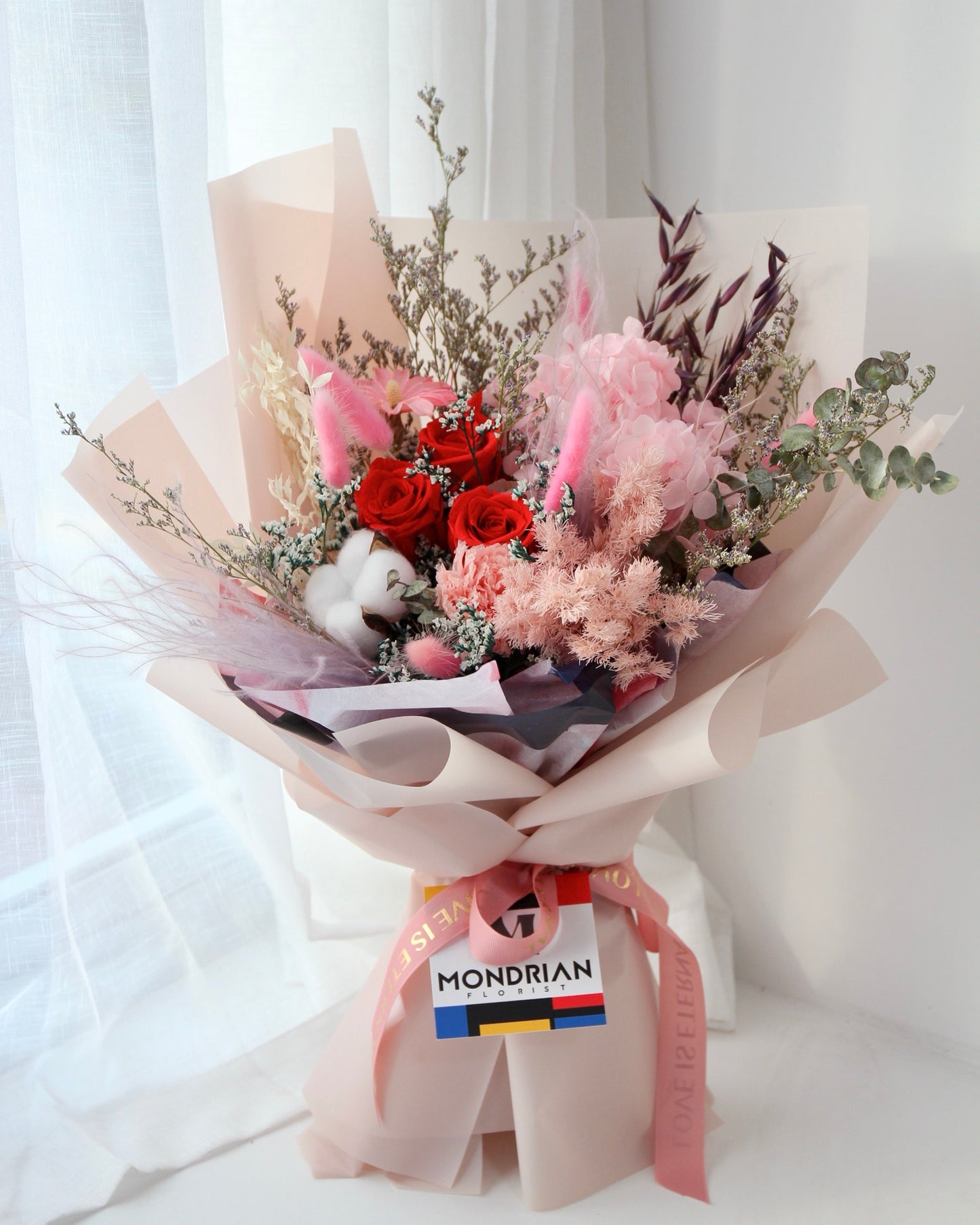 close up of a flower bouquet with preserved roses and assorted filler flowers including preserved hydrangea