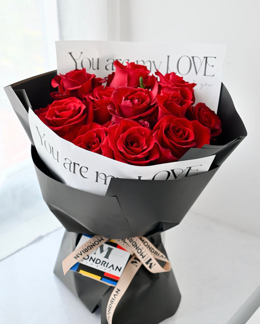 a flower bouquet with 12 stalks of kenya red roses in black wrapping paper