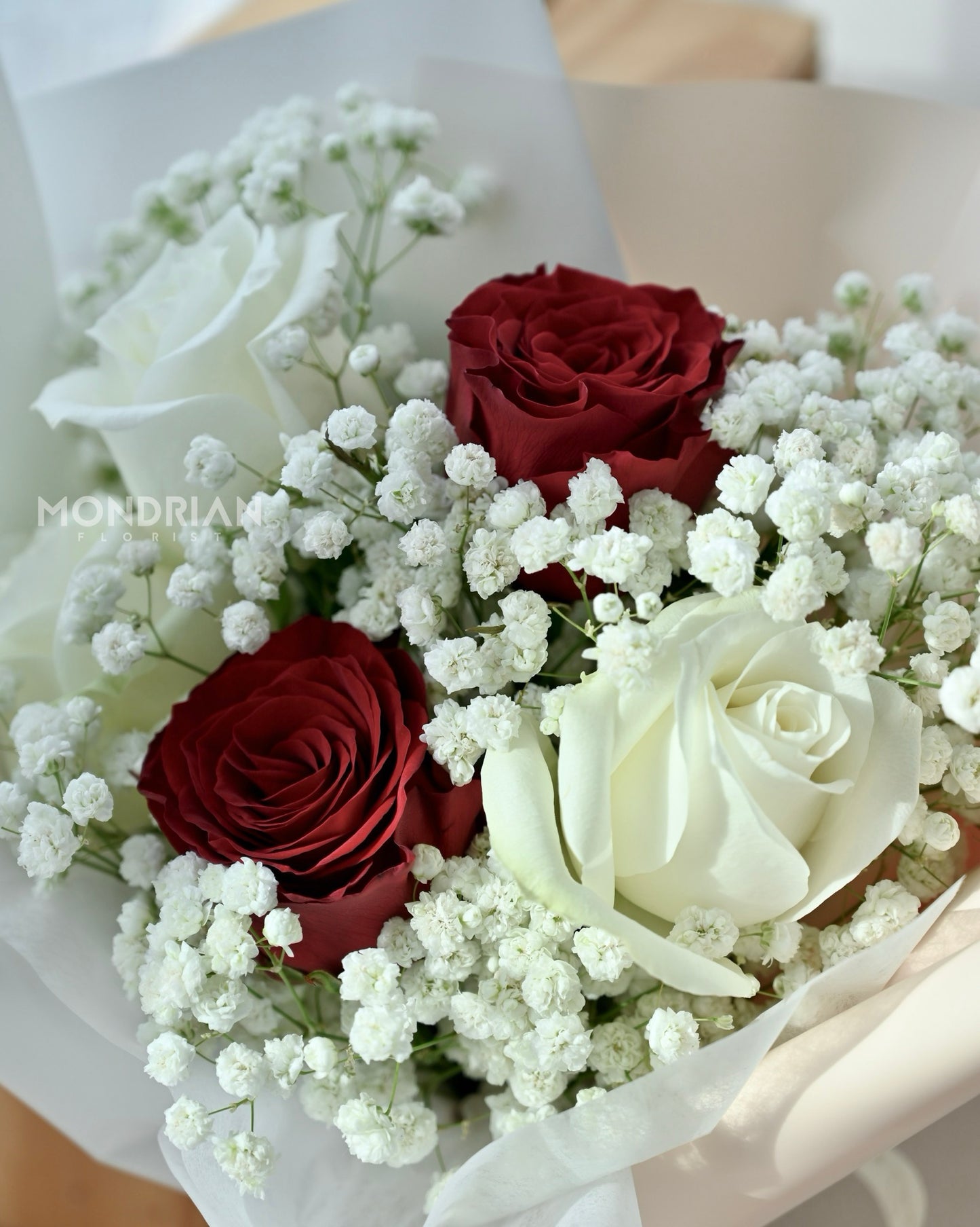 close up of a bouquet of mixed red and white roses with baby's breath by Mondrian Florist SG