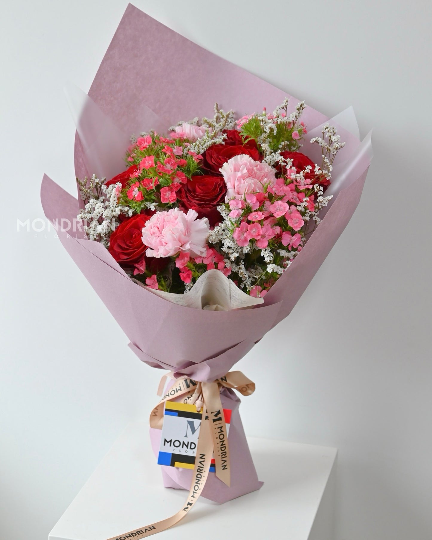 a bouquet of red roses, pink carnation and sweet william flower made by Mondrian Florist