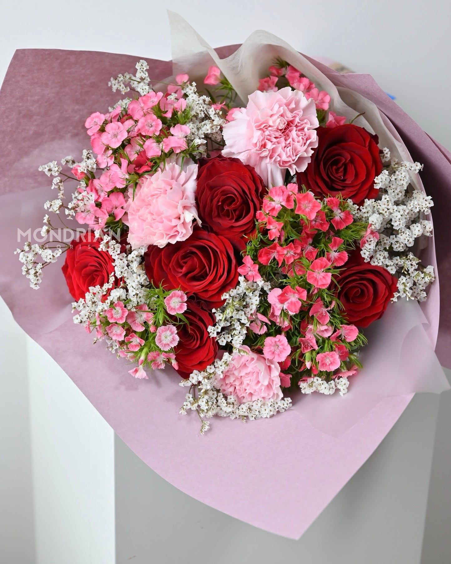 a bouquet of red roses, pink carnation and sweet william flower made by Mondrian Florist