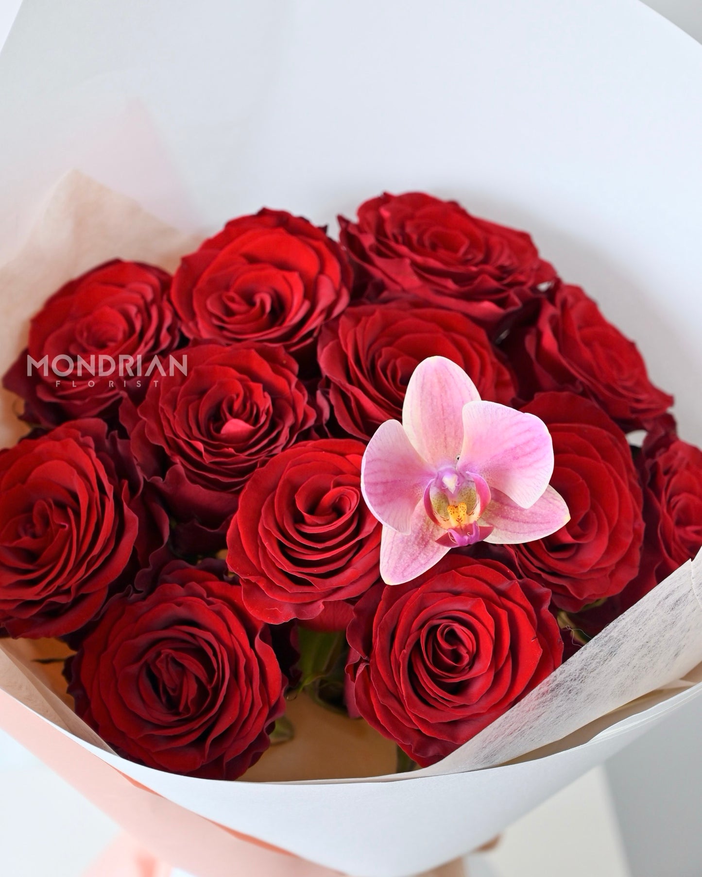 a bouquet of red roses and Phalaenopsis orchid by Mondrian Florist