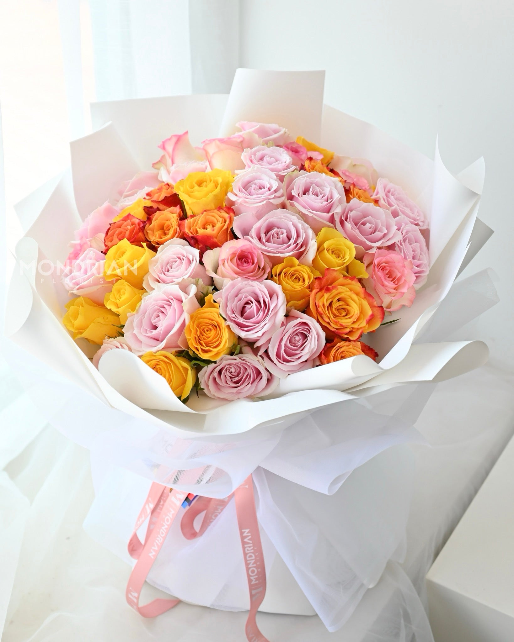 a 50 stalks rose bouquet in brightly mixed colors, with pink, yellow and orange roses
