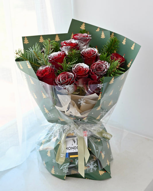 a christmas flower bouquet with red roses and nobilis fir