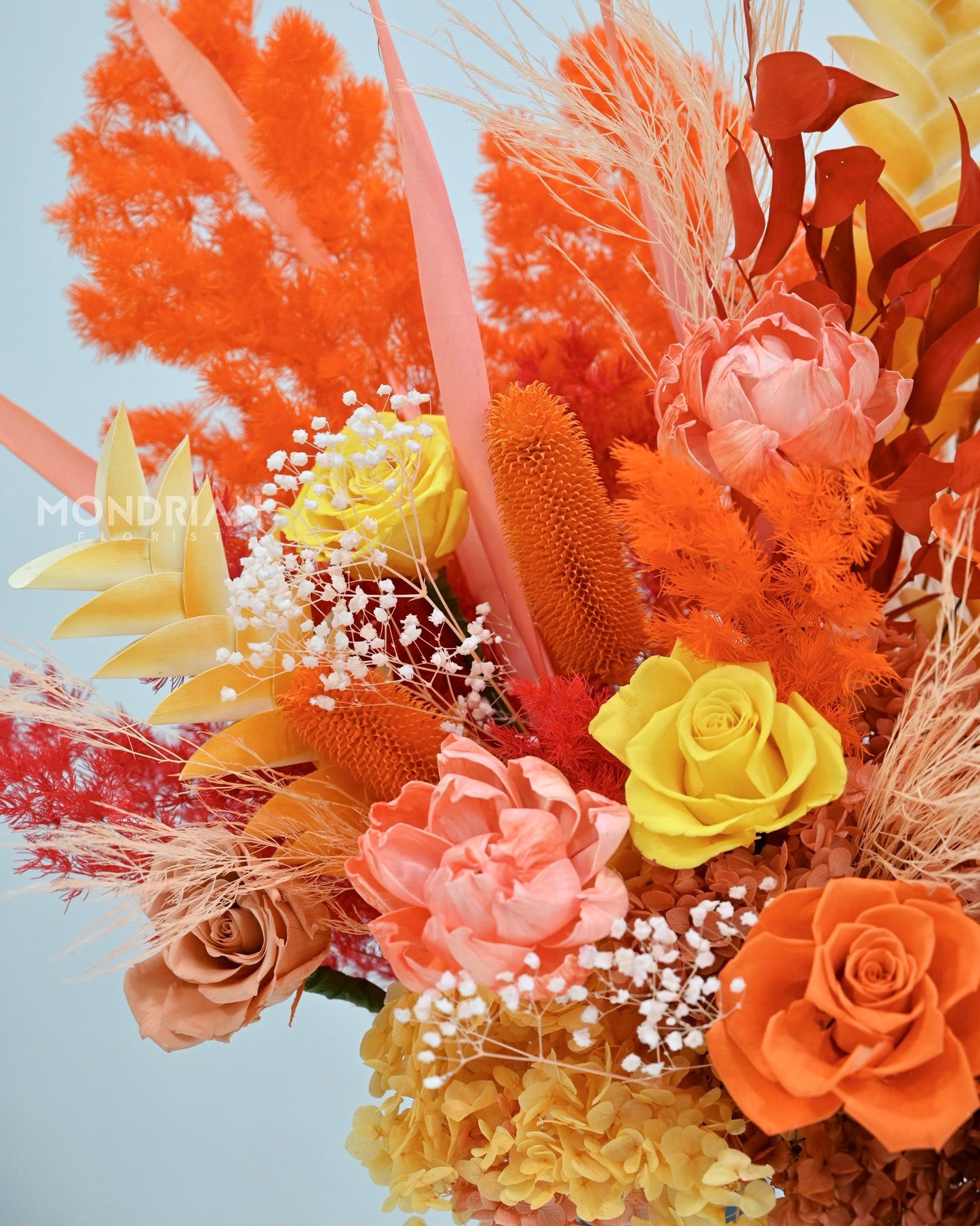 close up of a luxury box of dried flowers and preserved roses, in warm orange and amber color