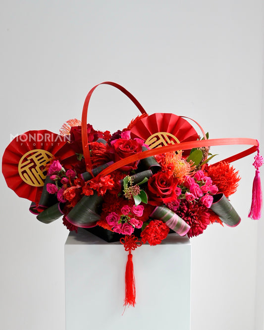 a lux table arrangement of red and shocking pink roses, with chinese new year elements