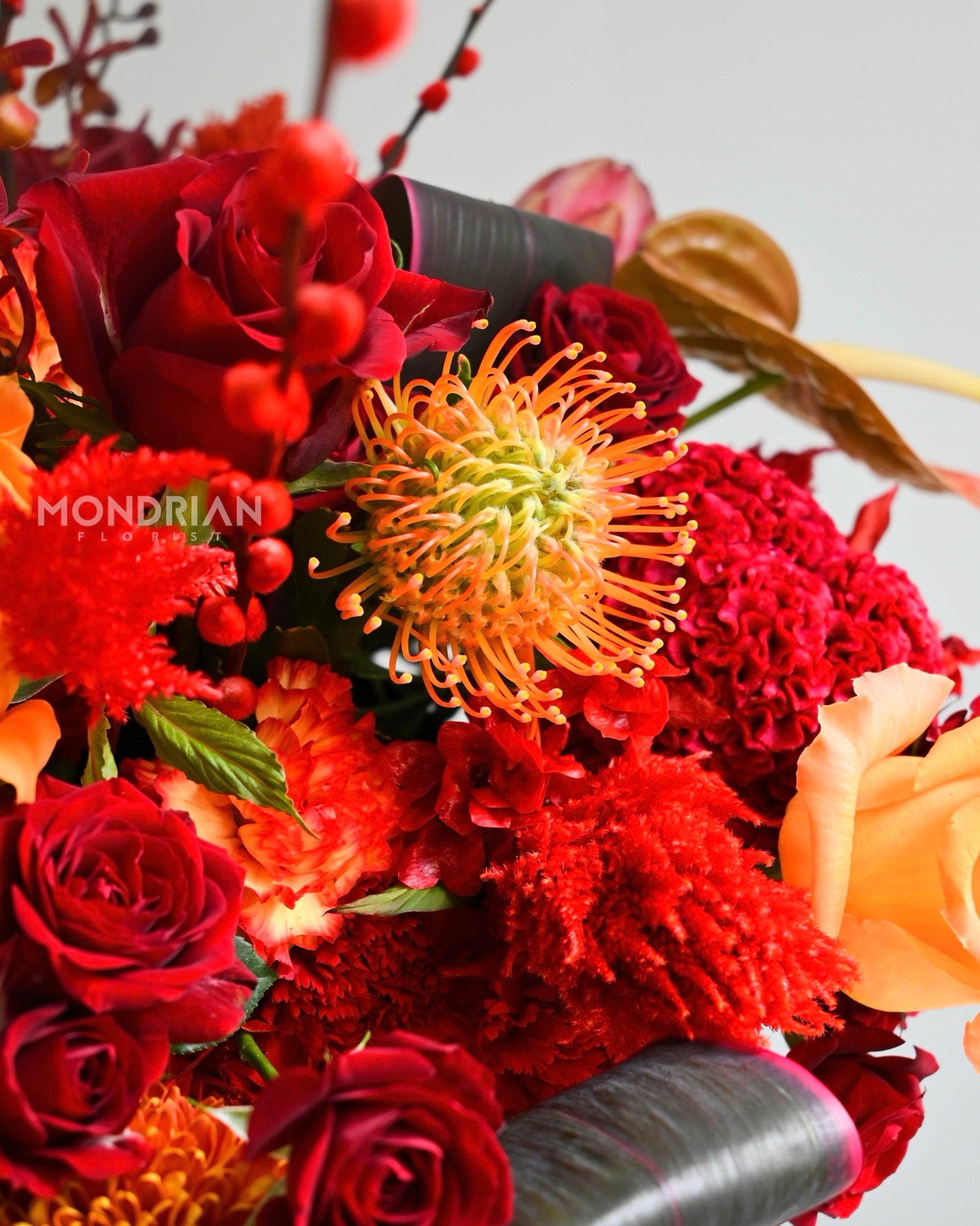 close up of a luxury fresh flower table arrangement using red and orange flowers for chinese new year