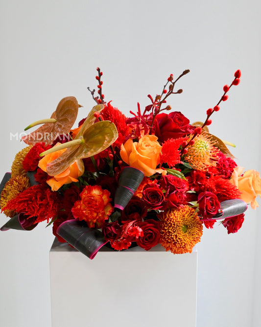a luxury fresh flower table arrangement using red and orange flowers for chinese new year
