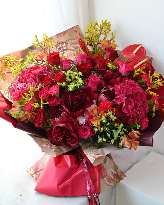 a luxury flower bouquet with red peony, red roses, anthurium and many more flowers by Mondrian Florist