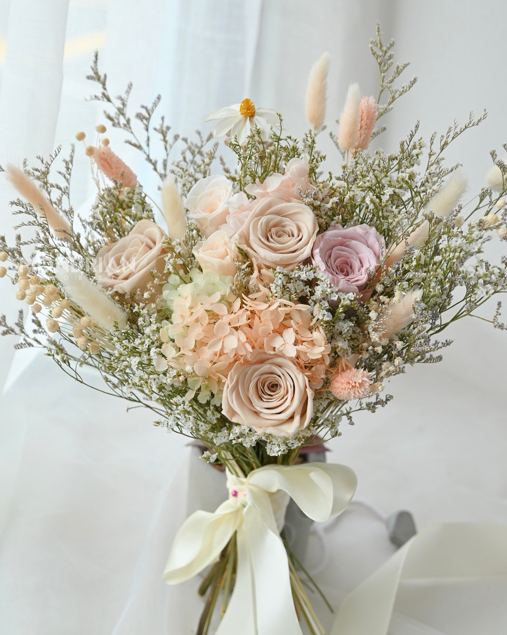 A bridal bouquet made with preserved roses and dried flowers in pastel hue.