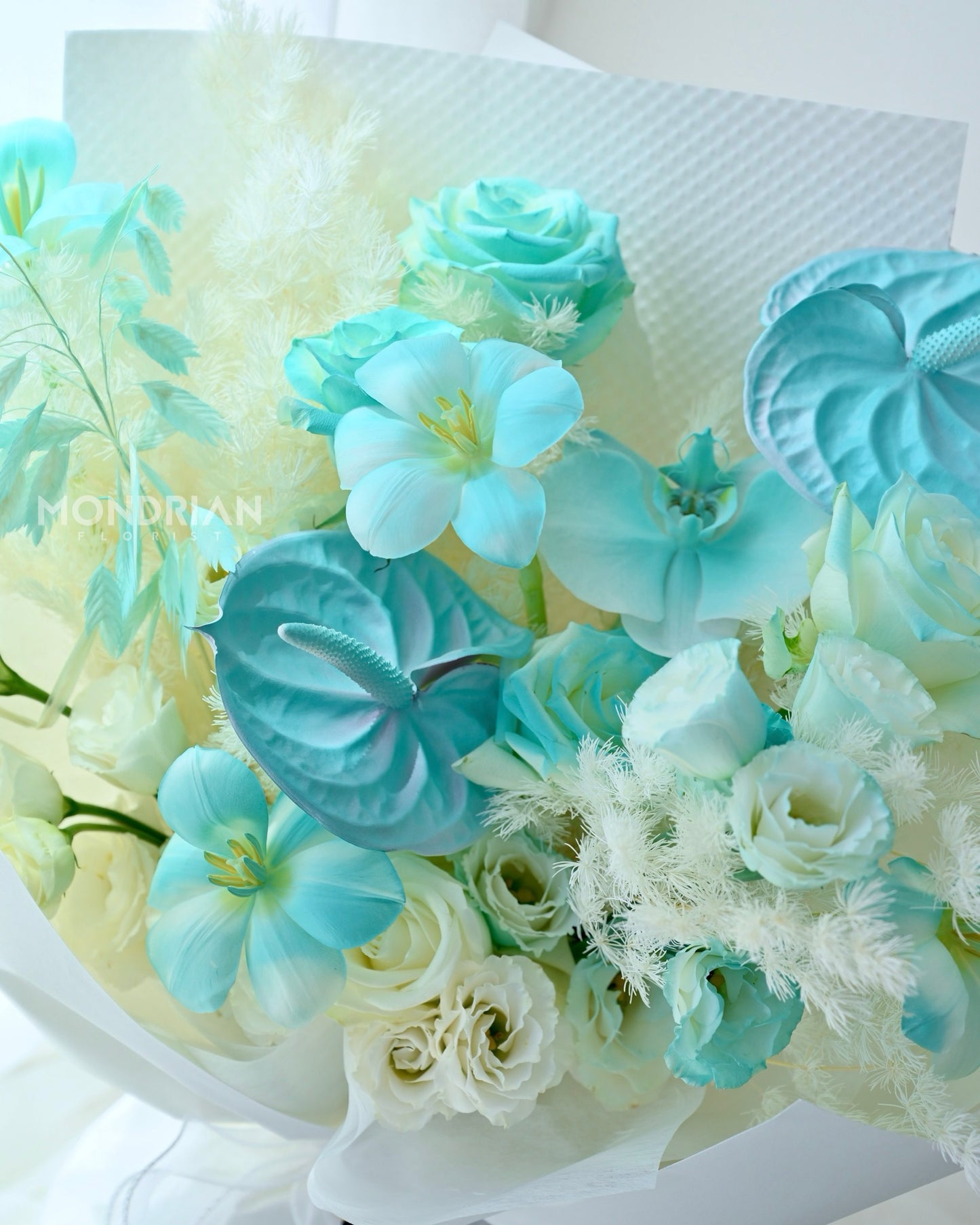 a fresh flower bouquet with tiffany blue roses, tulips and anthurium